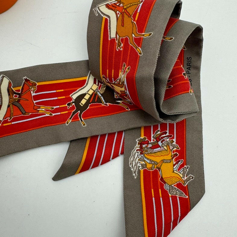 Hermès Gray Twilly Scarf with Orange and Red Equestrian Print 32x2 Inches.