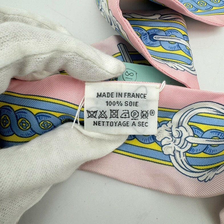 Hermès Twilly Silk Scarf Pink, Blue, and Yellow Pattern 32x2 Inches.