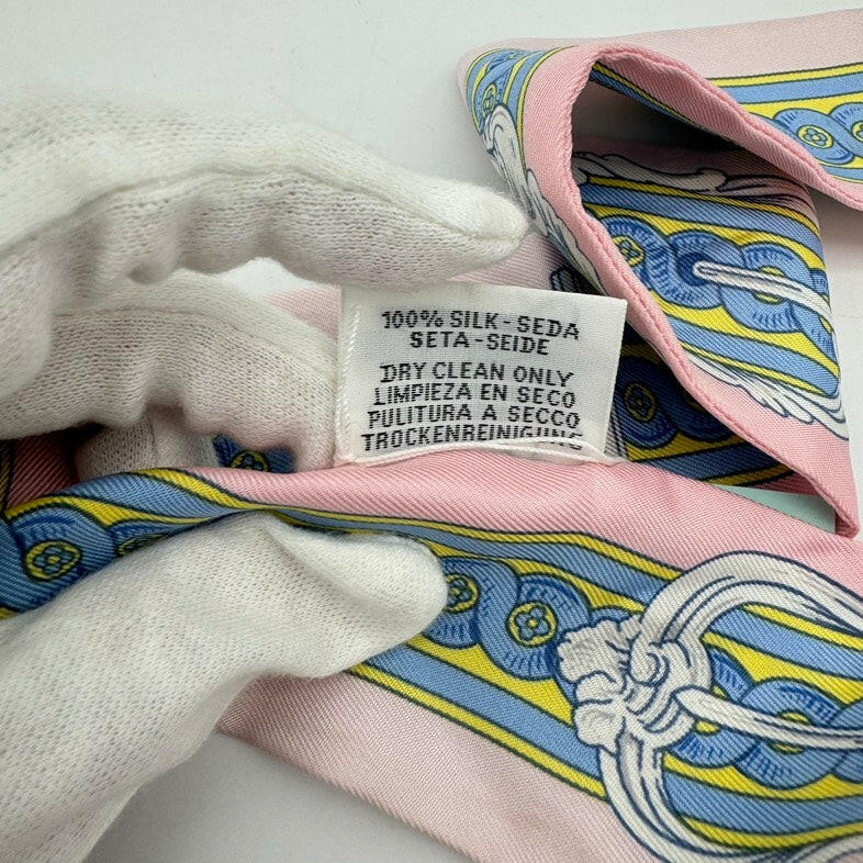 Hermès Twilly Silk Scarf Pink, Blue, and Yellow Pattern 32x2 Inches.